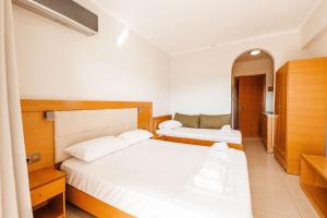Habitación de hotel con 2 camas y espejo en Hotel Marialena en Potos
