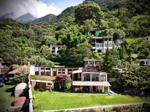 a house on a hill with mountains in the background at Casa Mariposa San Marcos Atitlán Lakefront Retreat in San Marcos La Laguna