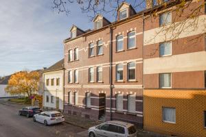 a large brick building with cars parked in front of it at Stilvolle Ferien-und Monteurunterkunft Leverkusen in Leverkusen