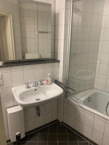 a bathroom with a sink and a tub and a mirror at Altes Forstamt in Xanten