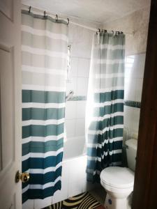 y baño con aseo y cortina de ducha. en CASA GUADALUPE SAN FELIPE en San Felipe