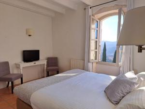 ein Schlafzimmer mit einem großen Bett und einem Fenster in der Unterkunft Hôtel restaurant Clos des Sullys in Montclus