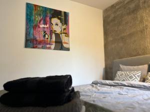 a painting hanging on a wall next to a bed at Red Chapel in Łagów
