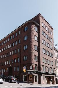 un grand bâtiment en briques dans une rue de la ville avec un feu de circulation dans l'établissement Nordstay - Bright Studio in the heart of Helsinki self check-in, à Helsinki