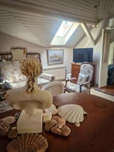 貝爾格勒的住宿－KLARA Vracar，一张桌子上一个女人的雕塑,上面有贝壳