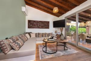 un soggiorno con divano e tavolo di Ilaira Sea View Bungalow a Gennadi