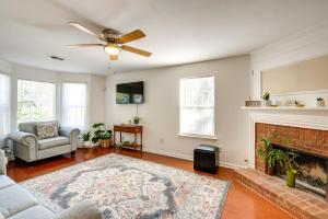 a living room with a fireplace and a ceiling fan at Atlanta-Area Home with Yard about 2 Mi to Six Flags in Austell