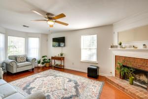 a living room with a fireplace and a ceiling fan at Atlanta Area Home with Yard about 2 Mi to Six Flags in Austell