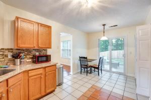 a kitchen with wooden cabinets and a table with chairs at Atlanta-Area Home with Yard about 2 Mi to Six Flags in Austell