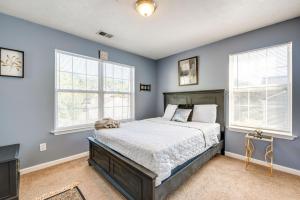 a bedroom with a bed with blue walls and windows at Atlanta-Area Home with Yard about 2 Mi to Six Flags in Austell