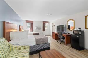 ダンバースにあるKnight's Inn Boston/Danversのベッドとデスクが備わるホテルルームです。