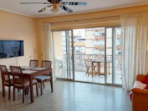 a dining room with a table and chairs and a balcony at Victoria, 8-22 in Cullera