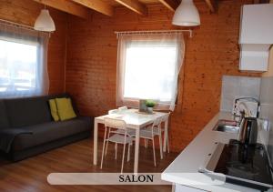 mała kuchnia i salon ze stołem i kanapą w obiekcie Michałówka Pokoje i Domki w mieście Karłów