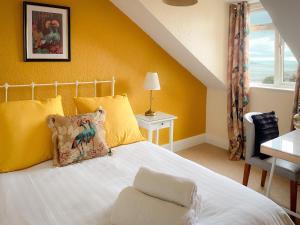 um quarto com uma cama com uma parede amarela em Timbertop Suites - Adults Only em Weston-super-Mare