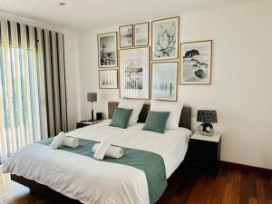 a bedroom with a large bed with pictures on the wall at Villa rospico, 200m de la plage avec piscine in Névez