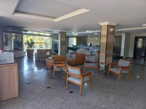 un hall avec des chaises et des tables dans un bâtiment dans l'établissement Fênix Hotel Campinas, à Campinas
