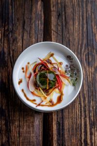 a white plate of food on a wooden table at Auberge du pont de l'Abîme in Gruffy