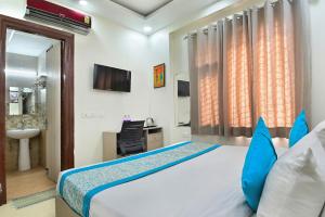 a bedroom with a bed with blue pillows and a sink at the indigo premium in Noida