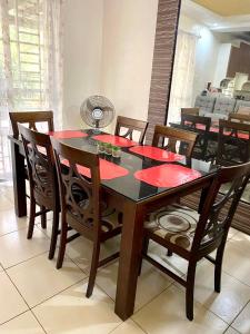 uma mesa de jantar e cadeiras com guardanapos vermelhos em Pumpkin Transient House em San Fernando