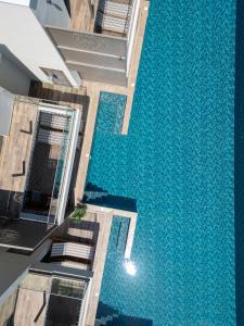 a swimming pool in the middle of a house with a blue floor at Exotic Sea Boutique Adults Only in Protaras