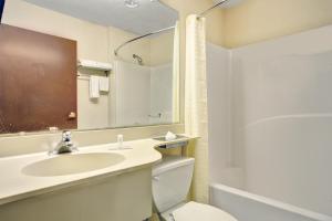 a bathroom with a sink and a toilet and a mirror at Stay Express inn and Suites Atlanta Union City in Union City