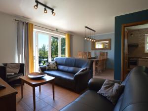 Picture perfect Holiday Home in Sourbrodt with Garden BBQ في سوربرودت: غرفة معيشة مع أريكة زرقاء وطاولة