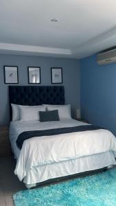 a blue bedroom with a large bed with a blue wall at Mo'Acress Lifestyle in Temba