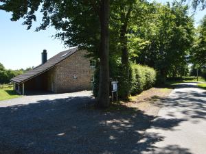 a brick building with a tree next to a road at Picture perfect Holiday Home in Sourbrodt with Garden BBQ in Sourbrodt