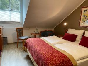 a bedroom with a bed and a table and a window at Hotel Alt Montjoie in Monschau