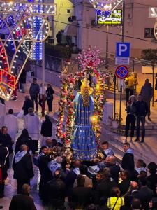 a crowd of people standing around a statue in a street at Una Biancasa in Carovigno