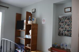 um quarto com uma parede com prateleiras e uma televisão em TY BIHAN em La Bernerie-en-Retz