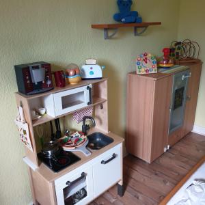 uma cozinha de brinquedo com um fogão a fingir e um micro-ondas em Ferienwohnung Leon em Langelsheim
