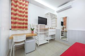 Habitación pequeña con escritorio y TV. en Il Giardino di Agata en Mascalucia