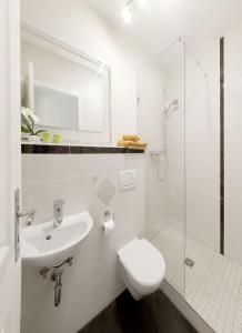 ズールにあるSuhler Stadtperleのトイレと洗面台を備えた白いバスルーム +4枚の写真