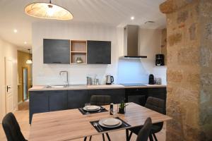 a kitchen with a wooden table and a table and chairs at Le Galiot in Figeac +4 photos