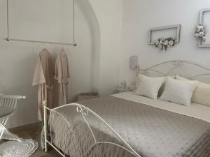 a white bedroom with a bed and a dresser at ELDOH’ in Bernalda