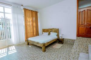 1 dormitorio con cama y ventana grande en Kigali Wings Apartment 7 A en Kigali