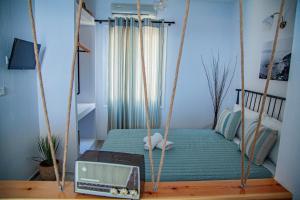a swing in a bedroom with a bed and a radio at Lalaros Apartment in Glossa