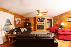 sala de estar con muebles de cuero y ventilador de techo en Pinnacle View 7C by Eden Crest, en Pigeon Forge
