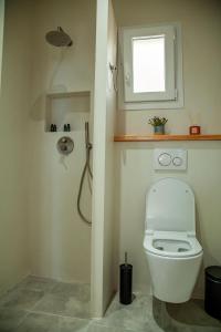 a bathroom with a toilet and a window at Lalaros Apartment in Glóssa +28 photos