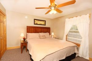 Un dormitorio con una cama y un ventilador de techo. en Pinnacle View 7C by Eden Crest, en Pigeon Forge