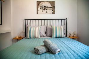 a bedroom with a bed with a blue comforter at Lalaros Apartment in Glossa