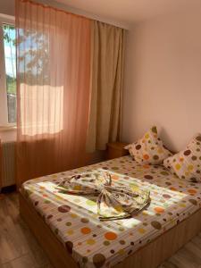 a bed with a plate on it in a bedroom at Casa Stoian in Costinesti