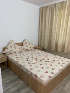 a bedroom with a bed with a bedspread with hearts on it at Casa Stoian in Costinesti