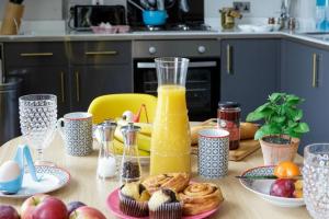 a table with breakfast foods and a blender of orange juice at Dream Stays Bath - Beau Street in Bath