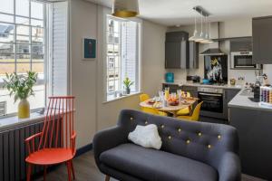 a living room with a couch and a table in a kitchen at Dream Stays Bath - Beau Street in Bath