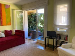 a living room with a red couch and a tv at Coloniola Lake House in Como