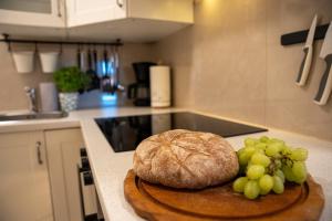 a loaf of bread and grapes on a cutting board in a kitchen at Ferienhof Kruse Wohnung Nr 5 in Grömitz