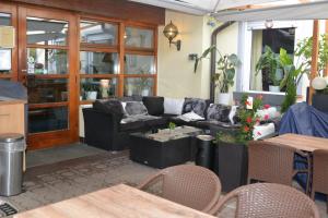 a living room with a couch and tables at Hotel-Gasthof Zur Rose in Weißenhorn