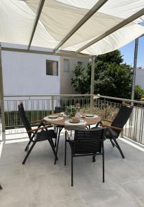 a table and chairs under an umbrella on a patio at Olive green house in Skiathos +54 photos